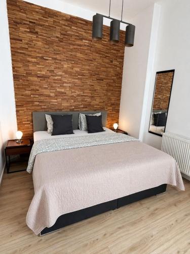 a bedroom with a large bed with a brick wall at GuestNest-Erfurt in Erfurt
