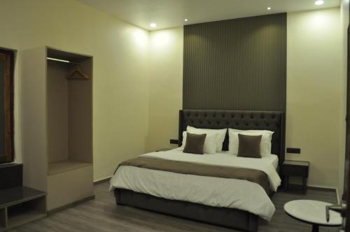 a bedroom with a large bed with white sheets and pillows at The Royal Palace Inn in Almora