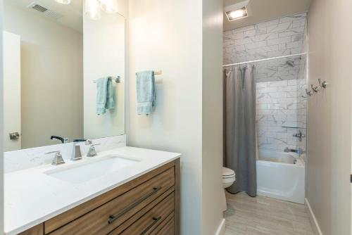 a white bathroom with a sink and a shower at Lake Walk Cottage in Black Mountain