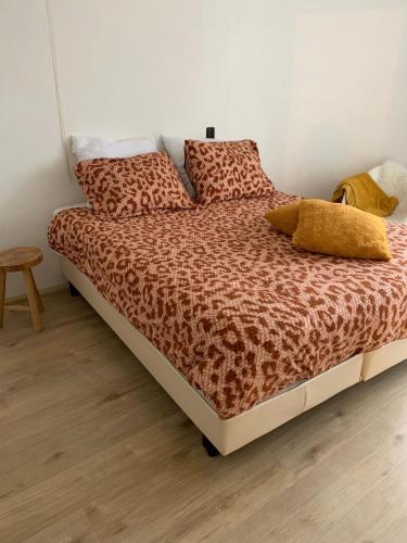 a bedroom with a bed with a leopard print sheets and pillows at Appartement Zuiderzeestate Makkum in Makkum