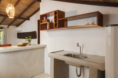 a kitchen with a sink and a counter at Pousada Nativa in Caraíva