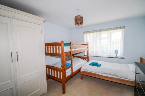 a bedroom with two bunk beds and a window at 50 Harbour Road in Bognor Regis