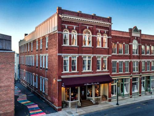 a large red brick building on a city street at Hotel Orlo in Greensboro