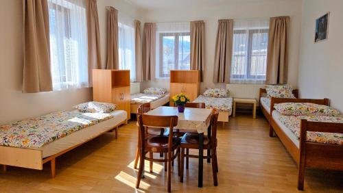 a room with beds and a table and chairs at Prázdninový dům Sloup - Sloup v Čechách in Sloup