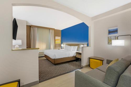 a hotel room with a bed and a couch at Comfort Suites Sumter near Shaw AFB in Sumter