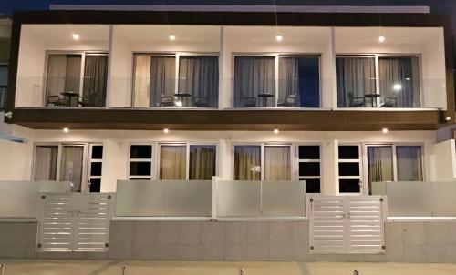 a building with white doors and windows at Shalos Studios - Cozy Central in Ayia Napa