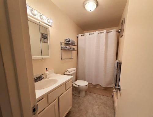 a white bathroom with a sink and a toilet at Fireweed Apartments in Fairbanks