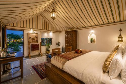 a bedroom with a bed and a desk in a room at Sky Desert Safari Jaisalmer & Spa in Jaisalmer