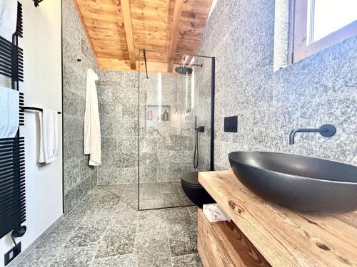 a bathroom with a black sink and a glass shower at Perla di Mergozzo 1 in Mergozzo
