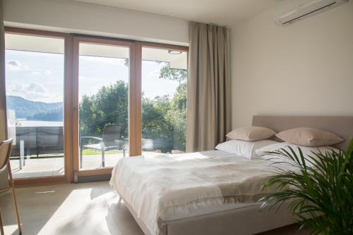 a bedroom with a bed and a large window at Domek Nad Jeziorem 6 osobowy in Rożnów