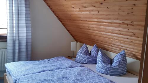 a bedroom with a bed with blue pillows on it at Ferienwohnung Brunk in Altefähr
