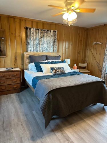a bedroom with a large bed and a ceiling fan at Waterfront Cottage, Fiery Sunsets in Charlotte
