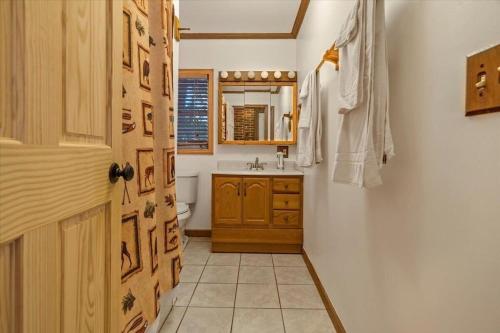 a bathroom with a sink and a toilet and a door at Waterfront Cottage, Fiery Sunsets in Charlotte