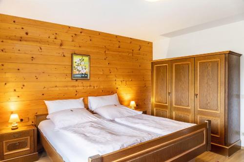a bedroom with a large bed with a wooden wall at Ferienwohnung Parterre in Wallgau