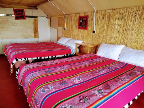 a room with two beds in a room with at Uros Suyawi Titicaca Lodge in Puno