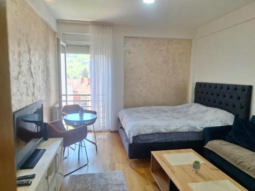 a small room with a bed and a couch at Apartman Selma - Bijelo Polje in Bijelo Polje