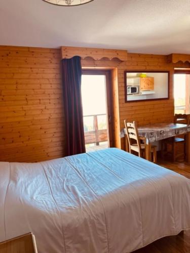 a bedroom with a bed and a dining room with a table at studio le Bouquetin 304 in Chamrousse