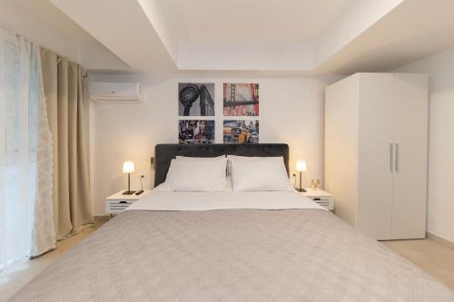 a white bedroom with a large bed and two lamps at CentRooms Kovac in Zadar