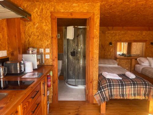 a kitchen with a bed and a shower in a room at Caledonian Glamping in Cannich