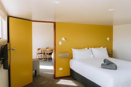 a bedroom with a bed and a yellow wall at The Mayfair in Hastings