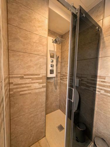 a shower with a glass door in a bathroom at 4 Seasons Apartment in Taverne