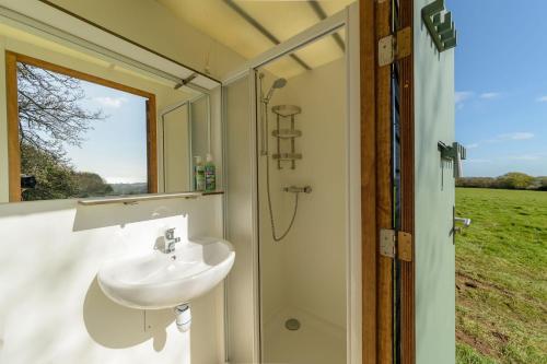 Barrel Cabin 1 في سانت أوستيل: حمام مزود بحوض غسيل ودش مع نافذة