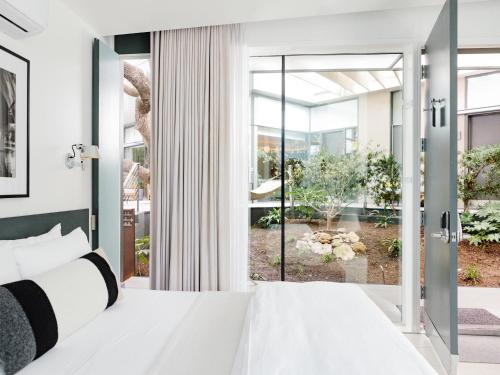 a bedroom with a white bed and sliding glass doors at Frame Hotel - Treehouse in Austin