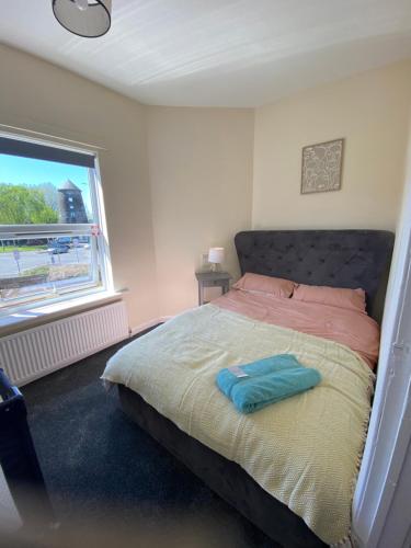 a bedroom with a bed with a blue pillow on it at Cute Central House Sleeps 4 in Stafford