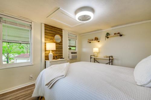 a bedroom with a white bed and a window at Lakefront Ozarks Home w/ Private Dock & Patio! in Roach