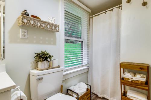 a bathroom with a toilet and a window at Lakefront Ozarks Home w/ Private Dock & Patio! in Roach