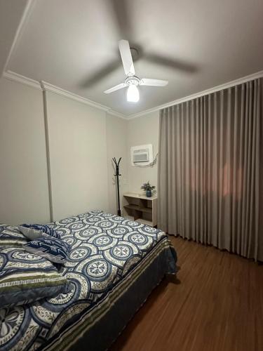 a bedroom with a bed and a ceiling fan at Apê do Viajante in Vila Velha