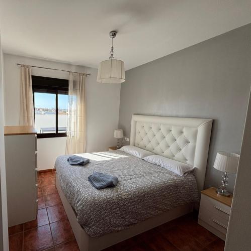 a bedroom with a bed with two towels on it at Ático luminoso con terraza privada in Sanlúcar de Barrameda