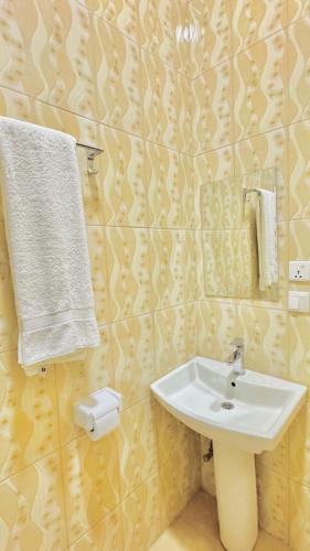 a bathroom with a sink and towels on the wall at Montana Stay B&B in Ruhengeri