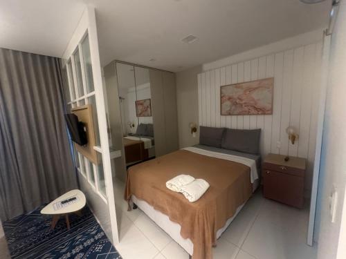 a small bedroom with a bed and a television at 808 Vista para o Mar in Salvador