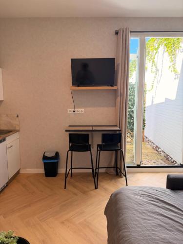 a bedroom with a desk with a television on the wall at Modern luxury studio near City Center Eindhoven in Eindhoven