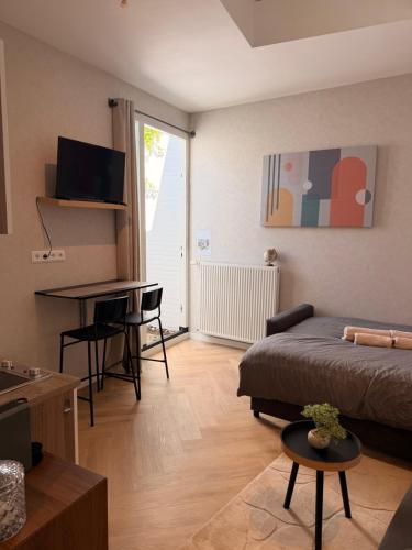 a small living room with a bed and a desk at Modern luxury studio near City Center Eindhoven in Eindhoven