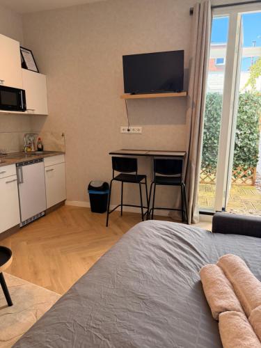 a room with a bed and a kitchen with a table at Modern luxury studio near City Center Eindhoven in Eindhoven