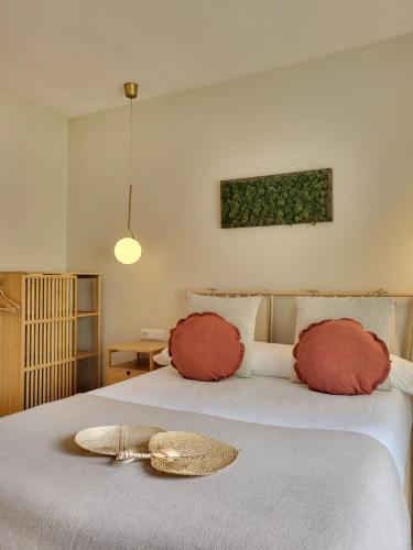 a bed with two pillows and a hat on it at Hotel Celta in Vigo