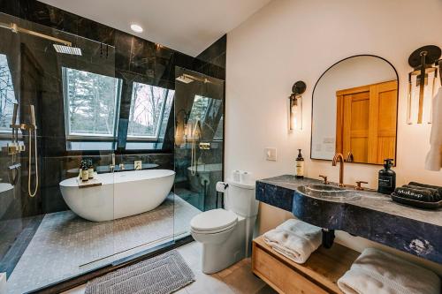 a bathroom with a tub and a toilet and a sink at Green Mountain Yay Frame in Killington
