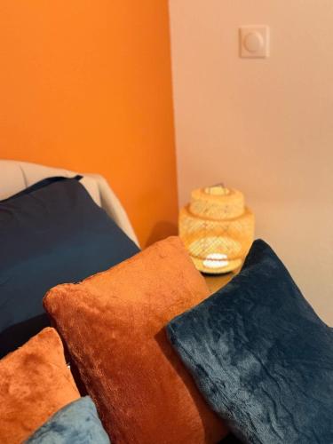 a pile of pillows sitting on a bed with a alarm clock at Cocon Terracotta - Netflix et Parking in Scheibenhard