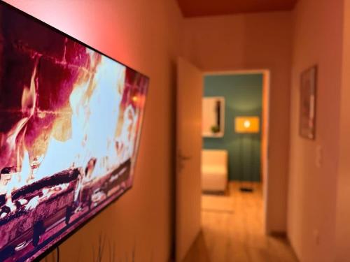 a flat screen tv hanging on a wall in a room at Cocon Terracotta - Netflix et Parking in Scheibenhard
