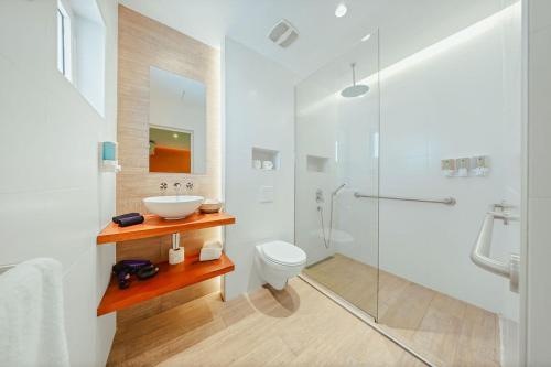 a white bathroom with a sink and a toilet at Walk to Beach - Private Pool Villa in Palm-Eagle Beach