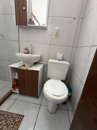 a bathroom with a toilet and a sink at Sol e mar in Serra