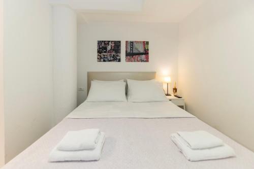 a white bed with two white towels on it at CentRooms Kovac1 in Zadar