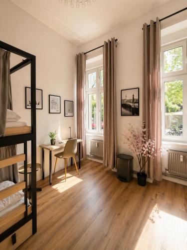 a bedroom with a bed and a desk and windows at Berlin Sleep Club in Berlin