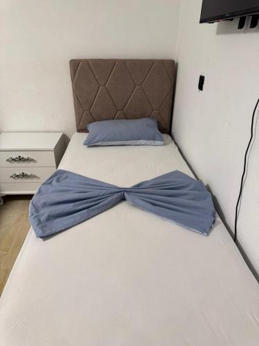 a bed with a blue bow tie on it at Apartmani Edi Ulcinj in Ulcinj