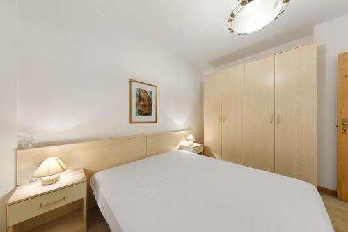 a bedroom with a white bed and wooden cabinets at Tabià Padola in Padola