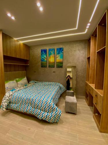 a bedroom with a large bed in a room with shelves at Nile residence in Al Kawāmil Qiblī