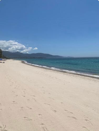 a sandy beach with the ocean in the background at Casa Roberta a due passi dal mare in Quartu Sant'Elena