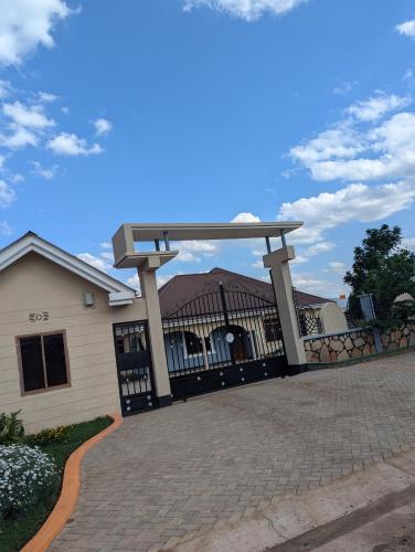 a gate to a house with a roof at New Harambee Hotel in Nakwa